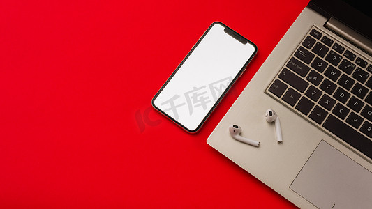 俄罗斯图拉 — 2019 年 5 月 24 日：红色背景中的苹果 iphone X 和 Airpods，带笔记本。