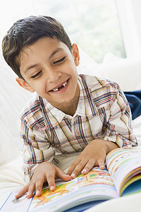 看书距离摄影照片_客厅里看书微笑的小男孩（高调）