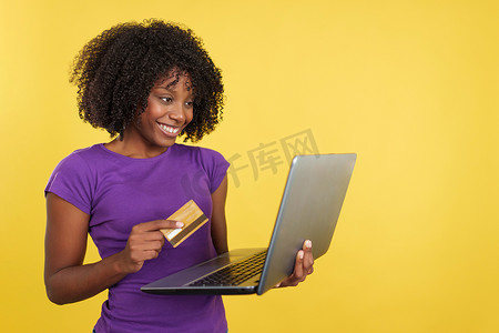 留着爆炸头的女人用笔记本电脑在网上购物
