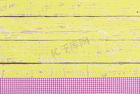 黄色木桌面背景纹理，带有质朴的紫色桌布