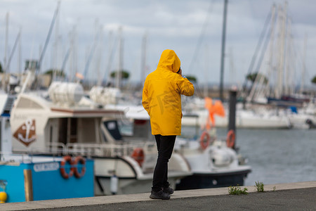 沿着渔港走的黄色油布的人