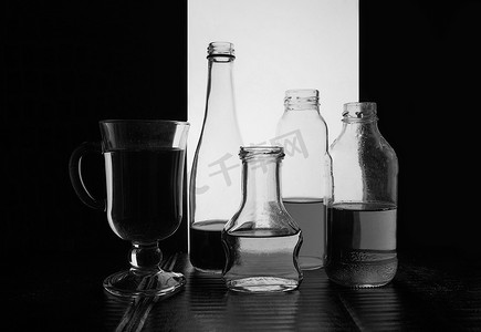 瓶装在浅色背景上，带有液体黑白剪影照片