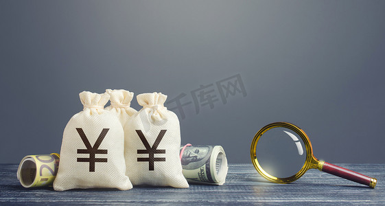 融资租赁摄影照片_日元钱袋子和放大镜。