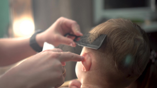 理发造型摄影照片_一个小孩正在理发。