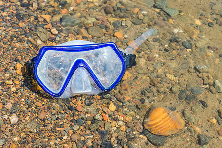 丢失的浮潜面具躺在水中的小石头上