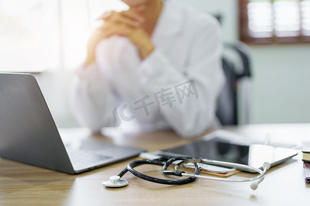 一位亚洲女医生在使用电脑时表现出对患者信息的关注