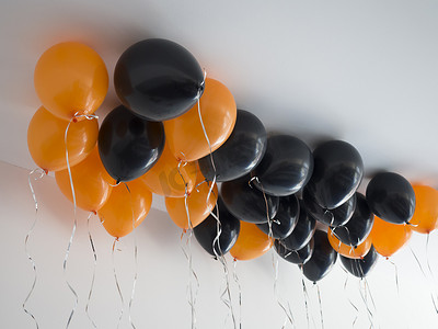 一堆橙色和黑色气球万圣节或白色天花板背景上的生日。