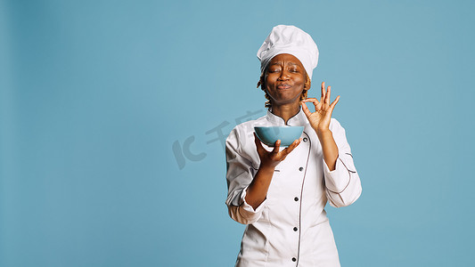 品味美食摄影照片_欢快的美食厨师从碗里闻到食物的香气