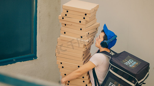 笨拙的食品快递员试图接住掉落的披萨盒