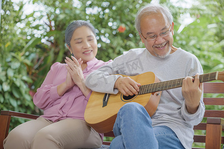 唱歌聚会摄影照片_年长夫妇老人弹吉他，而他的妻子一起唱歌