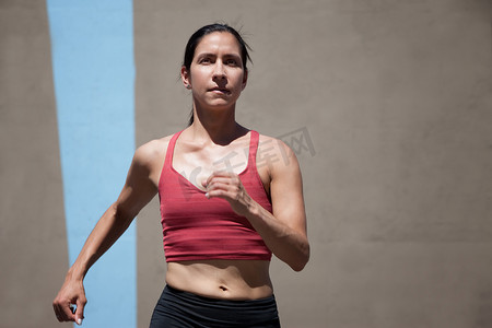 女人跑步摄影照片_漂亮、专注的女人跑步以保持体形。
