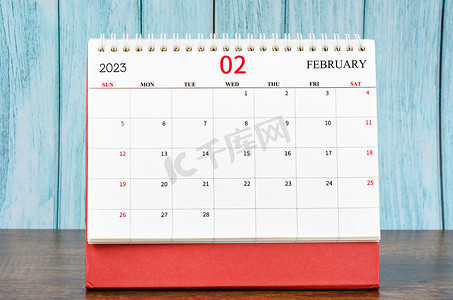 组织者在木桌上计划 2023 年的 2023 年 2 月月度台历。