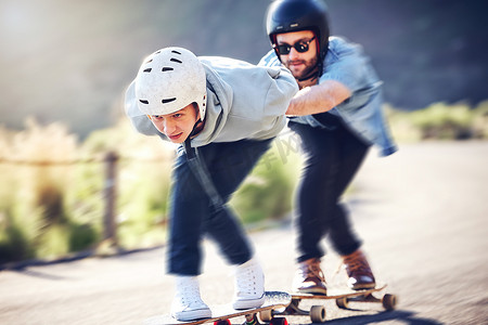滑冰，长板和朋友在路上快速骑行，为了安全，带着滑板和头盔竞速下坡。