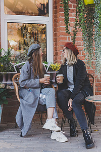 时间的朋友摄影照片_年轻女性最好的朋友在空闲时间互相交谈讨论有趣的主题嬉皮士女孩开玩笑和一起玩乐享受休闲与咖啡继续城市背景