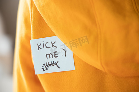 黄色粘纸，背面有文字 KICK ME 和鱼，特写。