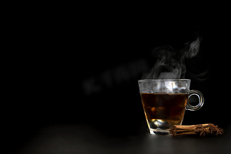 一杯刚泡好的红茶，逸出的蒸汽，温暖柔和的光线，较暗的背景。