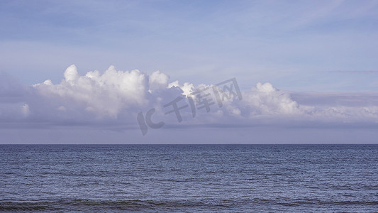 天空淡蓝色摄影照片_大气全景真实照片美丽的夏日白云清澈淡蓝色紫色调天空地平线平静空旷的大海。