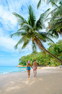 泰国普吉岛苏林海滩棕榈树散步的男女夫妇