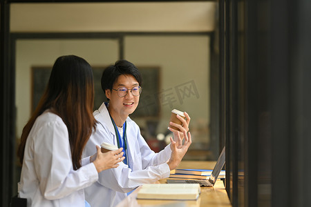 现代医院食堂休息时身穿白色制服的男女医生与同事交谈的镜头