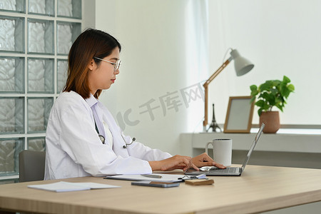 穿白大褂的医生在笔记本电脑上观看在线医学网络研讨会培训
