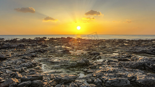 在低潮中发现的岩石海滩在晚上日落光 wi