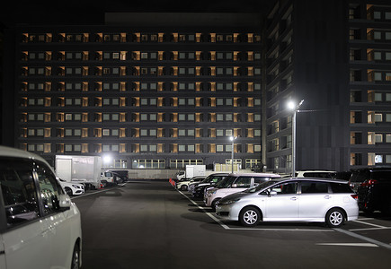 夜间多层酒店大楼旁的停车场