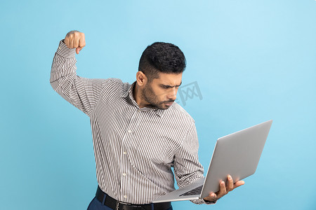 男子冲压笔记本电脑屏幕，表情疯狂，拳击威胁要在打电话时打人。