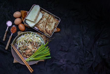 在陶瓷盘中用豆芽和细香葱炒软萝卜糕或炒萝卜糕 (chai tow kway)。