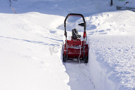 粮油日用摄影照片_冬日用扫雪机清理雪路上的路