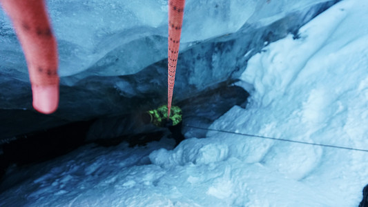 一名登山者下降到冰川的冰洞中。