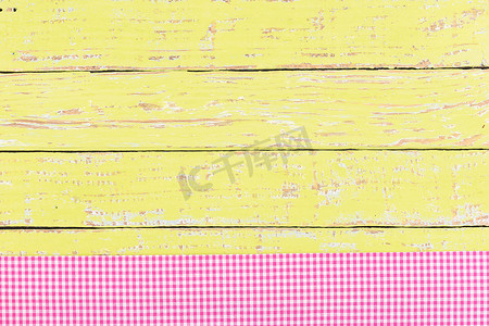 黄色木桌面背景纹理，带质朴的粉色桌布