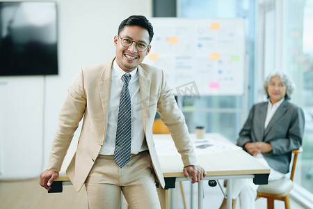 一位男性企业主的肖像，他在工作中使用计算机和财务预算文件成功地投资了他的企业时，脸上挂着快乐的笑脸
