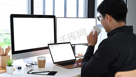 专业开发程序员在办公室喝咖啡和使用现代设备。