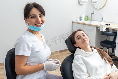牙齿矫正医生检查女性牙齿上的托槽。