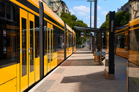 公共交通站一辆带有彩色窗户的现代黄色外伤巴士