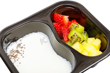 塑料碗中的酸奶甜点部分，包括草莓、猕猴桃和菠萝。