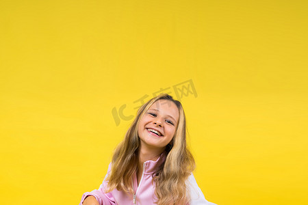 可爱的儿童美发师用黄色金属剪刀剪长长的金发