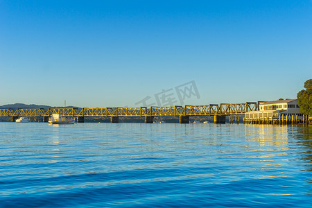 蓝色光芒摄影照片_陶朗加铁路桥从远处 ac 的日出中捕捉到光芒