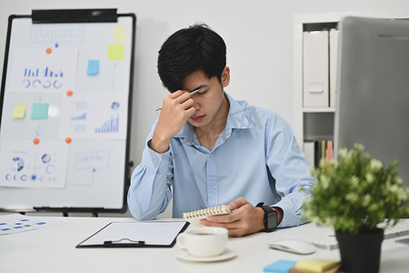 压力大的商人摸着头疼，因工作过度或工作压力而筋疲力尽