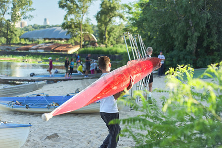 男孩青少年与运动船一起划皮划艇到河边散步