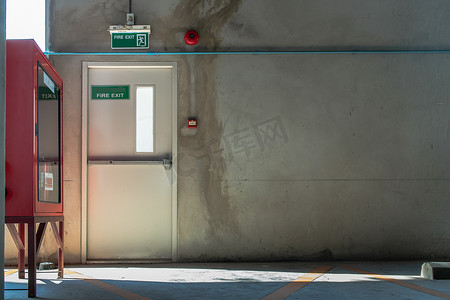 停车场大楼内带出口标志和红色消防设备柜的防火门或防火门。