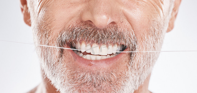 在灰色背景下孤立的工作室中，老人的牙科、牙线和嘴巴。