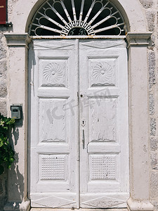 门石摄影照片_一座古建筑的石墙上有拱顶的白色木门