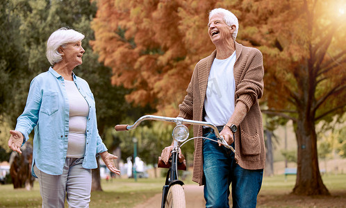 老人、夫妇和自行车在公园里进行自然散步和户外运动，老人和老妇人开着有趣的笑话开玩笑，还有生态友好的旅行。
