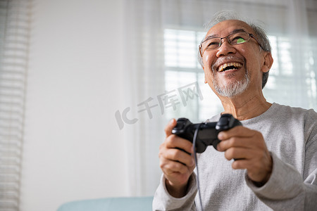 有趣的退休老人微笑坐在沙发上生活游戏