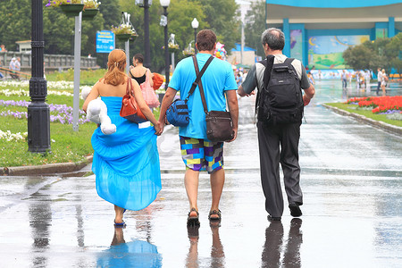 三个人在雨中走在街上