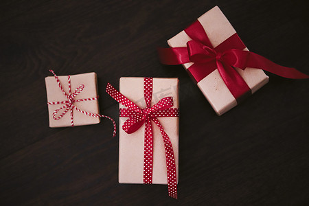 传统经典摄影照片_礼品和传统节日礼物，木制背景的经典礼盒，用红丝带工艺纸包裹的礼物，季节性假期的复古乡村风格