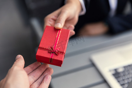 企业老板将礼物盒送给办公室员工合作伙伴，以获得工作奖金概念。