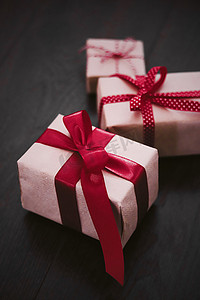 圣诞礼物和传统节日礼物，木制背景的经典圣诞礼盒，用红丝带工艺纸包裹的礼物，复古乡村风格的季节性假期