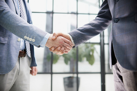 两位不同的专业商人行政领导在办公室会议上握手。